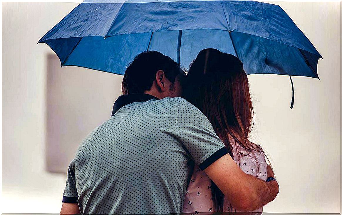 Couple under the umbrella representing the difference between child love and mature love