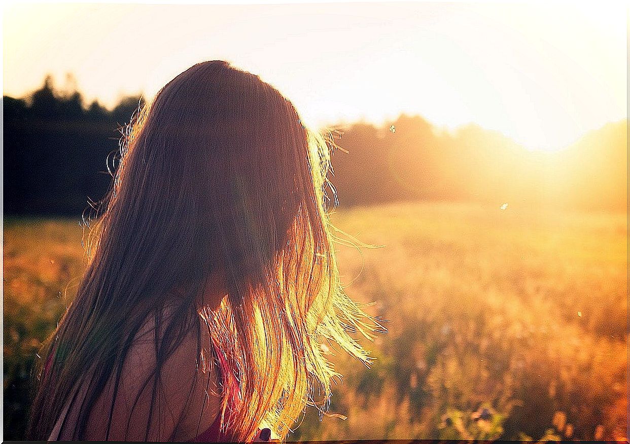 Woman thinking of happiness while walking in the field