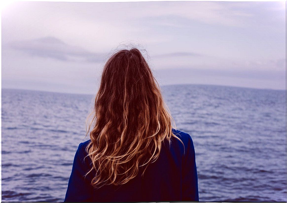 Woman looking out to sea with fear of the unknown