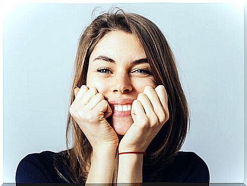 Woman smiling with hands on face