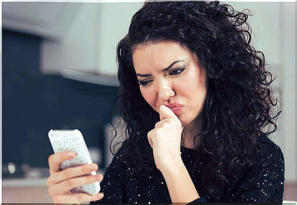 Woman looking at the mobile with doubt