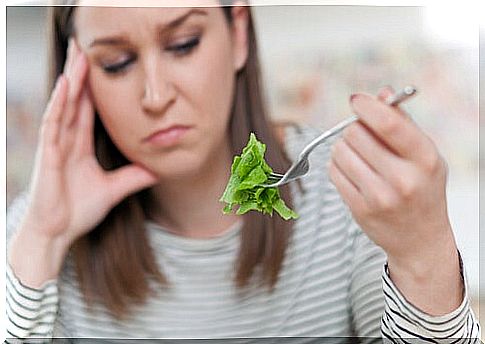 Woman with orthorexia looking at a piece of lettuce