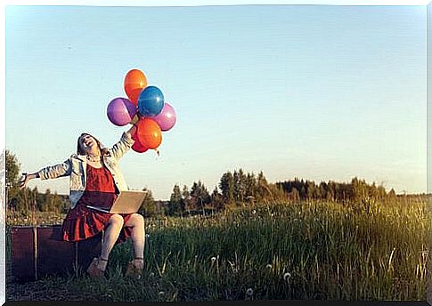 Woman with positive thinking holding colorful balloons