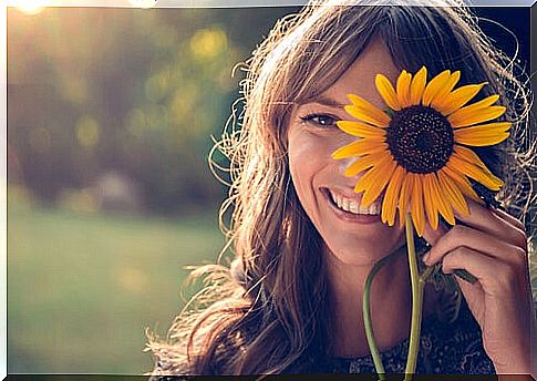 Girl smiling with a sunflower on her face