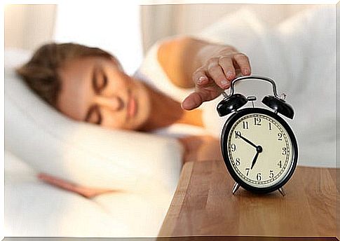 Woman turning off the alarm clock