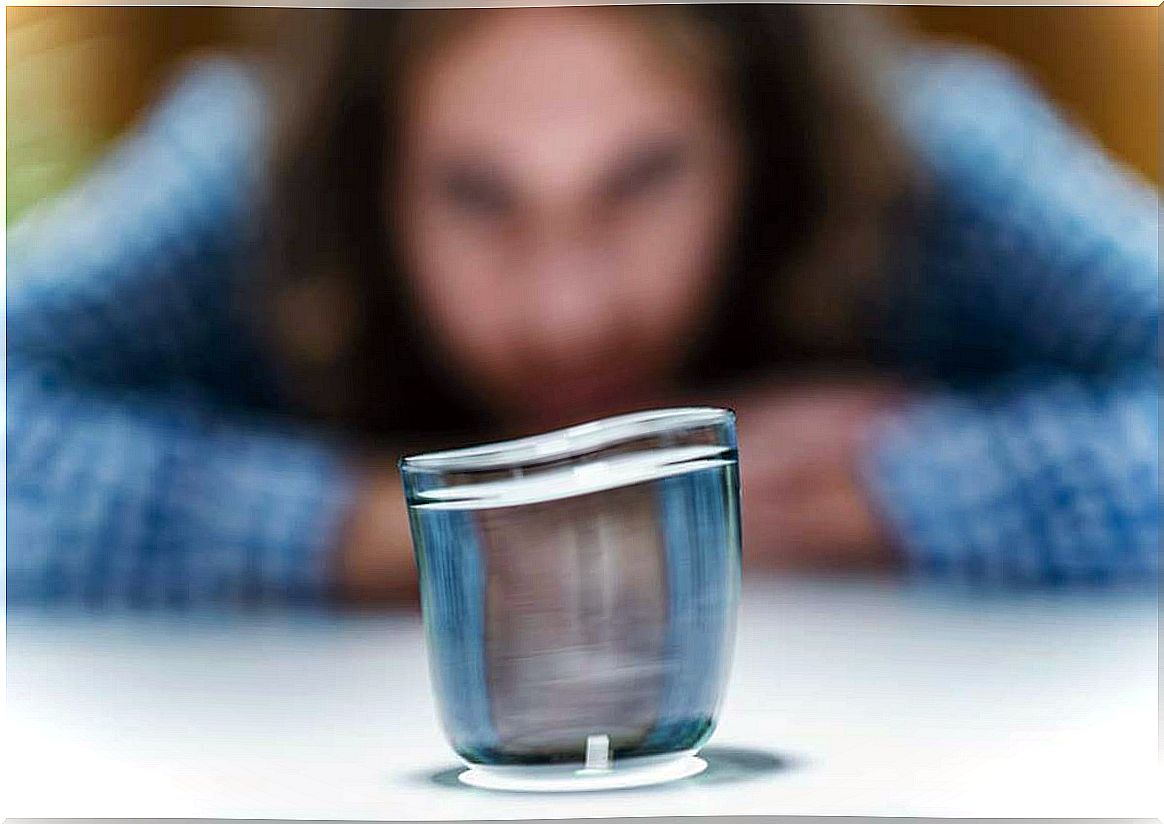 Woman practicing telekinesis with a glass