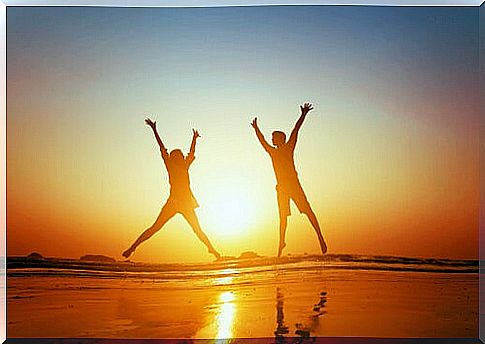 Happy couple jumping on the beach